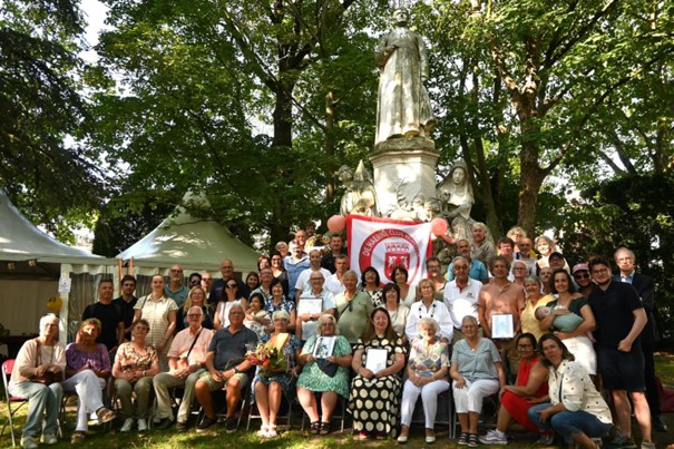 Beschrijving afbeelding: na de stadswandeling verzamelde iedereen voor het standbeeld van Monseigneur De Haerne in Kortrijk. Een groepsfoto van Bas De Wilde.